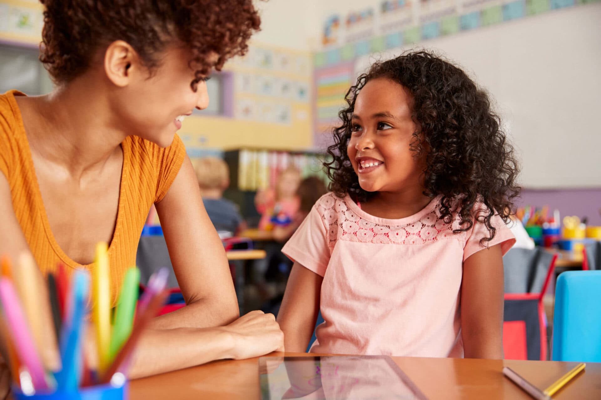 A teacher and a child smiling at each other in a Little Giants classroom